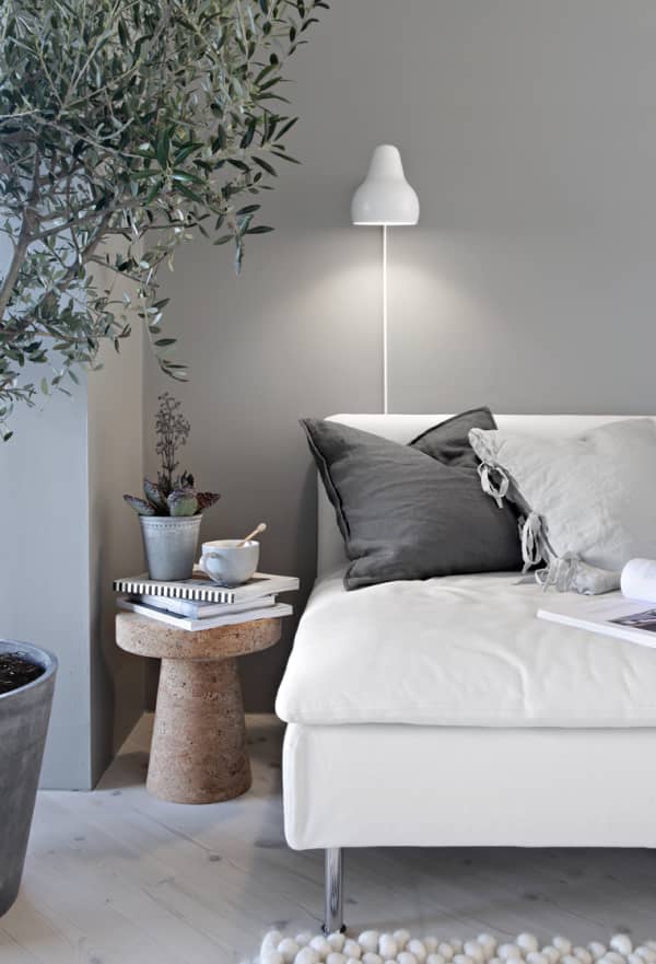 Sofa with soft cushions, a tea and few plants.