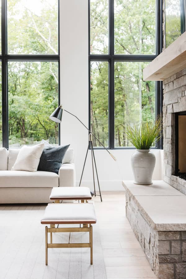 Relaxing sofa with a huge window behind with a view on nature.