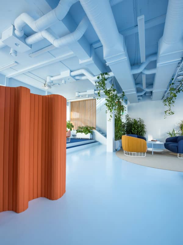 Office open space where the space is divided using acoustic room dividers and wood partitions.