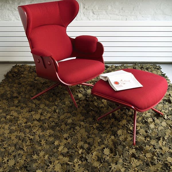 Red armchair on a rug made with little individual wood felt flowers.