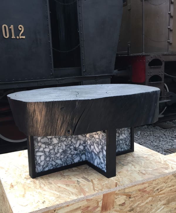 Black coffee table with wooden top and recycled plastic base; one of the plastic recycling design projects joining the Guiltless Plastic Initiative.