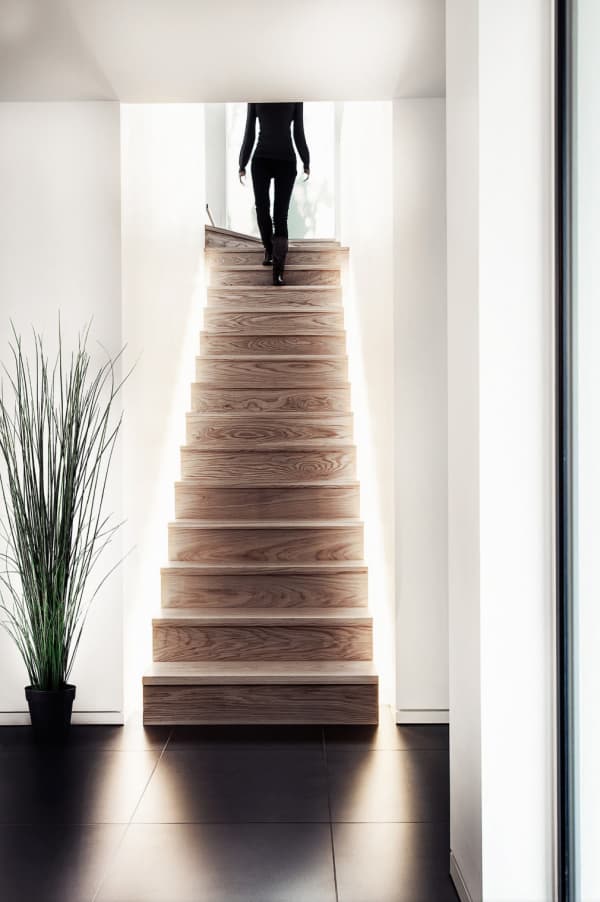 Black and white interior with a wooden staircase with marked wood graining.
