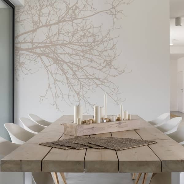 Dining room with a branch wallpaper on the wall.