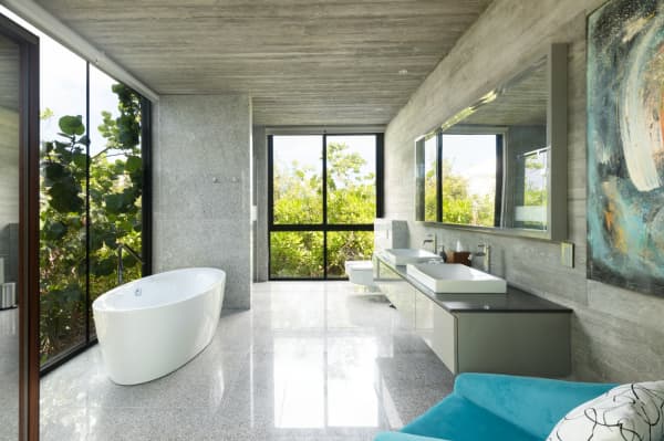 A bathroom of Villa Islander, with a free-standing bathtub in front of the window that looks directly into nature.
