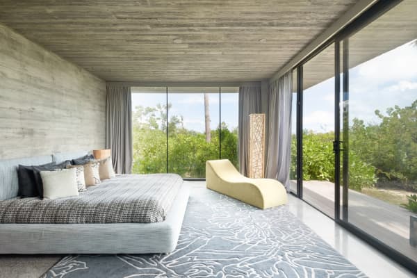 Bedroom of Villa Islander, with full-height windows that look into the forest.