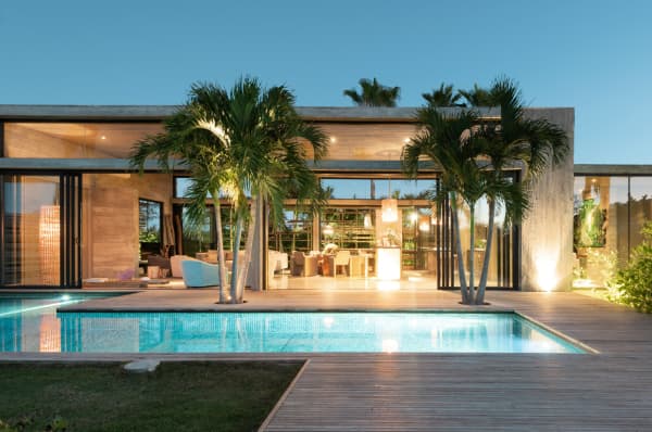 The pool area of Villa Islander, with wooden deck and palm trees.