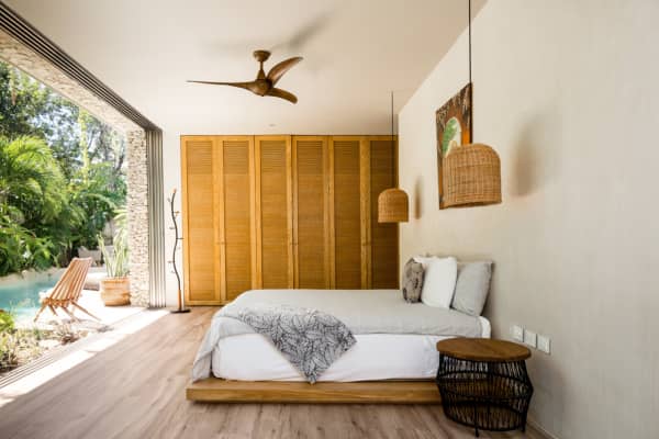 One of the bedrooms of Villa Verde, with a floor-to-ceiling window in front of the bed.