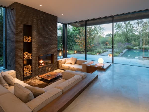 Biophilic living room with big windows leaving the view to the outside totally open.