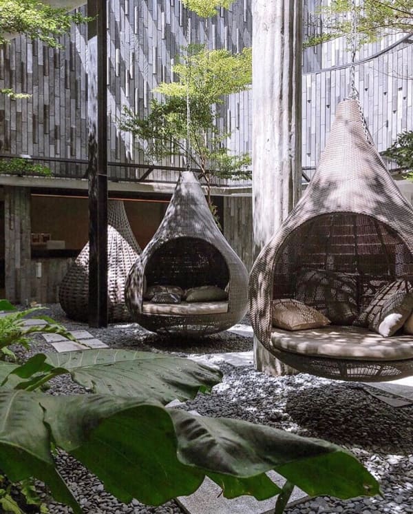 Outdoor refuge area with hanging chairs.