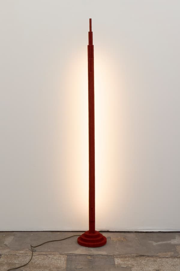 Floor lamp with wooden dowels as base.