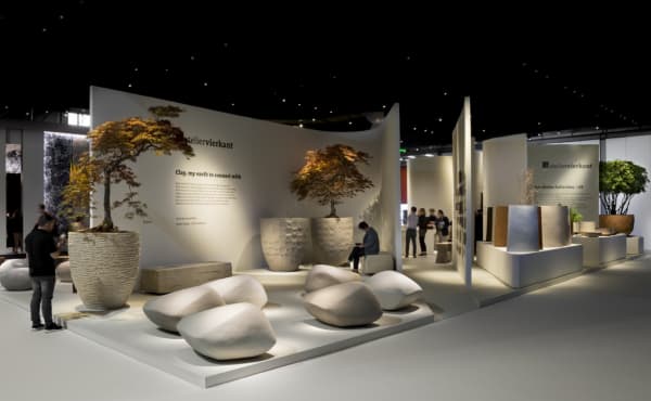 Booth with trees on huge textural planters.