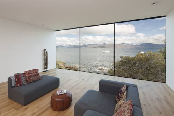Living room with a full-wall window looking into the sea.