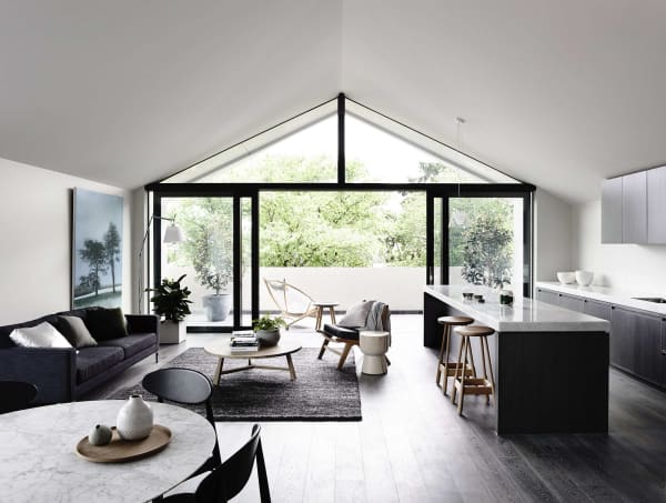 Elongated open plan living area with the back wall fully glazed.