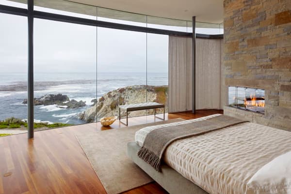 Bedroom with fully glazed wall looking into the sea.