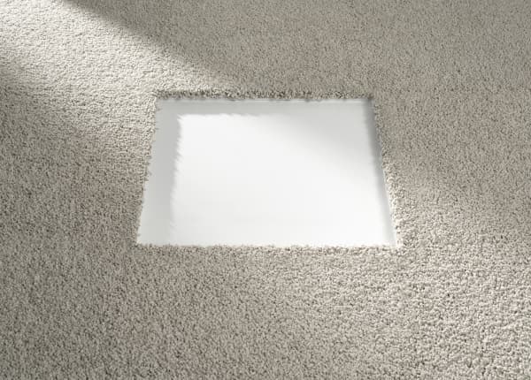 View of a modular rug where one tile has been removed for washing.