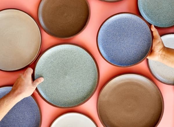 Flatlay shot of several Granbyware plates on an orange background.