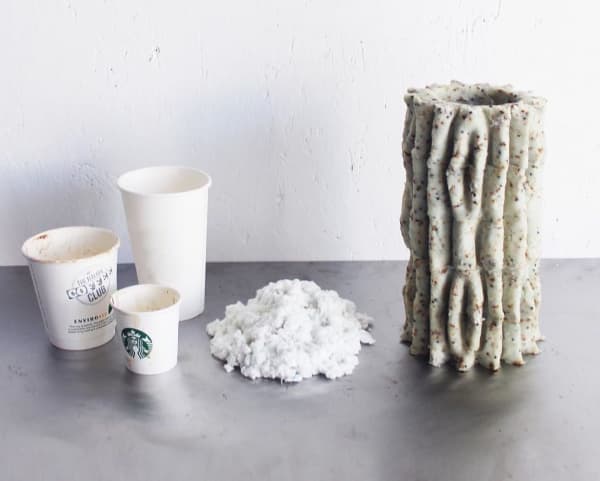 Trashed coffee cups next to a mycelium based vase.