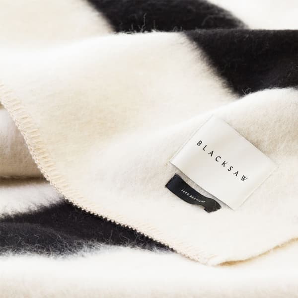 Close-up view of the blanket, clearly showing the "100% recycled" tag.