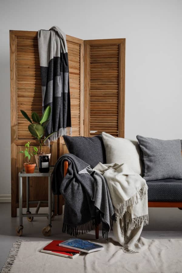 Shot of the blanket on a sofa with some more accessories around.