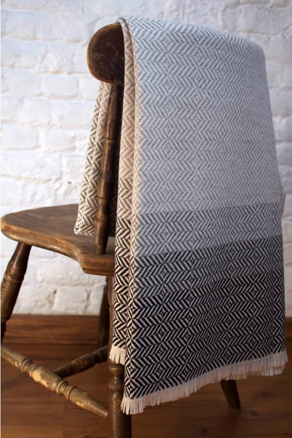 Grey blanket laying on a vintage wood chair.