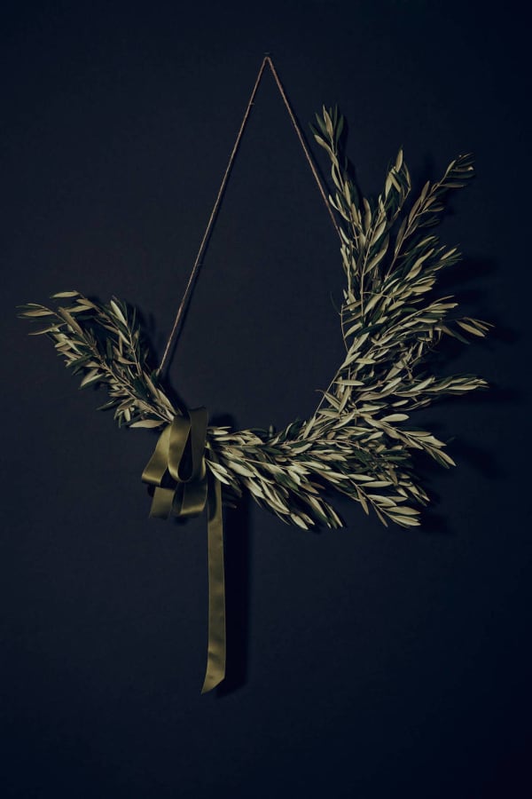 Olive twigs asymmetric wreath on a dark blue background.