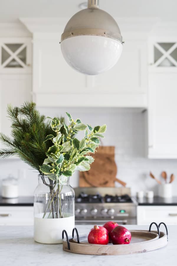 Real twigs on a vase and few pomegranates make for an understated decoration of the kitchen counter.