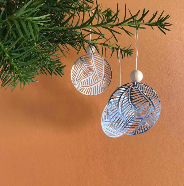 Paper cut ornament made with a silver foiled paper.