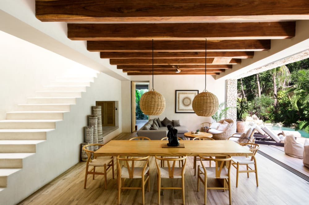 The dining area of Villa Verde, with wooden table and chairs and rattan pendant lights.<span class="sr-only"> (opened in a new window/tab)</span>