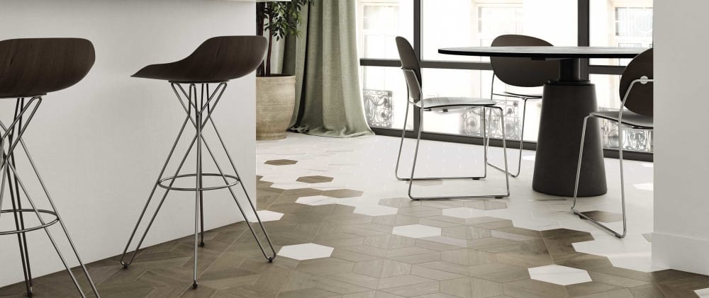 Grey hexagonal floor tiles intersecting with a wooden flooring.<span class="sr-only"> (opened in a new window/tab)</span>