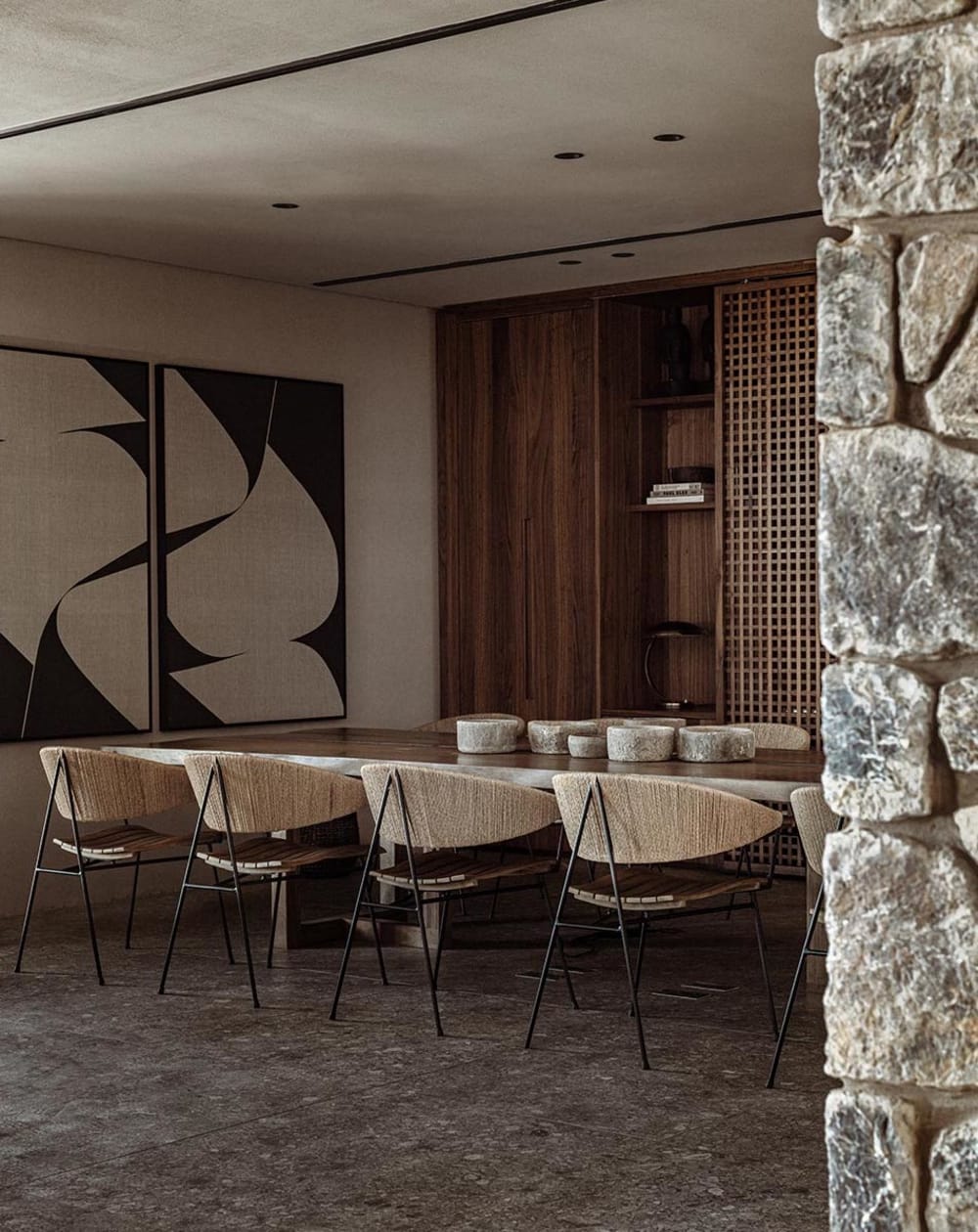 Biophilic dining room in the tones of Brave Ground. Raw stone wall and chairs with a rope back.<span class="sr-only"> (opened in a new window/tab)</span>