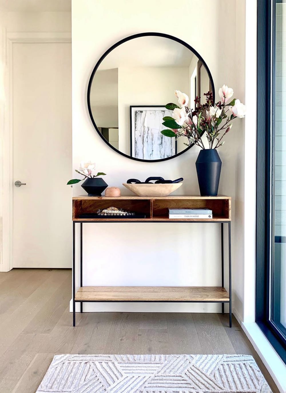 Airy contemporary entryway with a wood console and black accents.<span class="sr-only"> (opened in a new window/tab)</span>