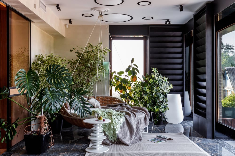 An indoor garden room with hanging sofa.<span class="sr-only"> (opened in a new window/tab)</span>