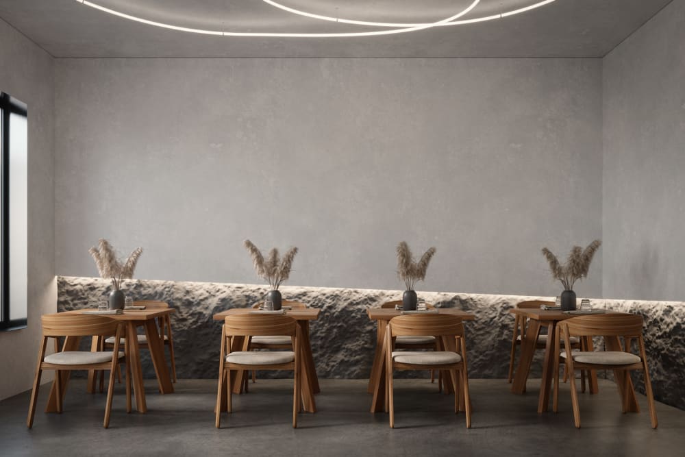 Minimal restaurant with plain walls and a raw stone bottom moulding.<span class="sr-only"> (opened in a new window/tab)</span>