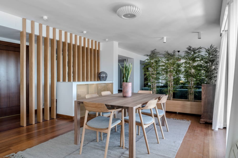 Tall plants visually dividing a dining room area.<span class="sr-only"> (opened in a new window/tab)</span>