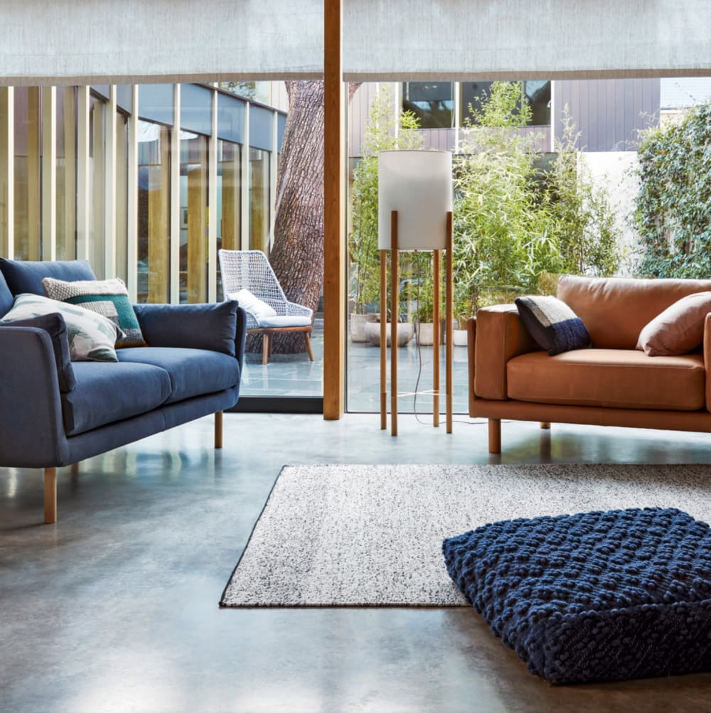 Living room with plenty of cushions, a rug and a floor cushion to add coziness.<span class="sr-only"> (opened in a new window/tab)</span>