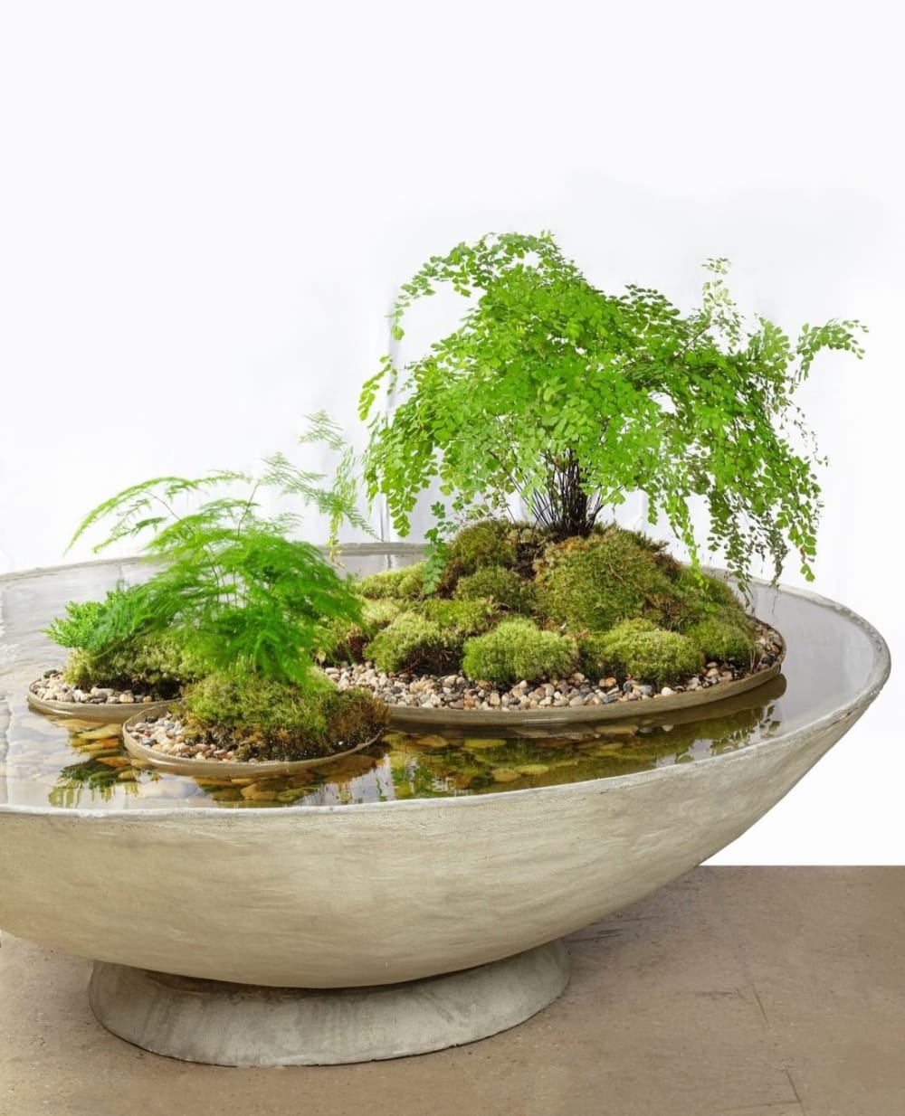 Huge vessel filled with water containing floating smaller vases with plants.<span class="sr-only"> (opened in a new window/tab)</span>
