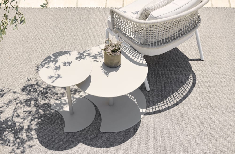 Silouette of branches reflecting on tables on a pation.<span class="sr-only"> (opened in a new window/tab)</span>