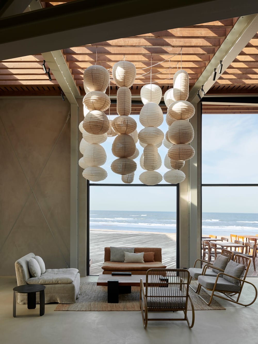Contemporary sitting area in a restaurant with a colour and material palette that recalls the beachy surroundings.<span class="sr-only"> (opened in a new window/tab)</span>