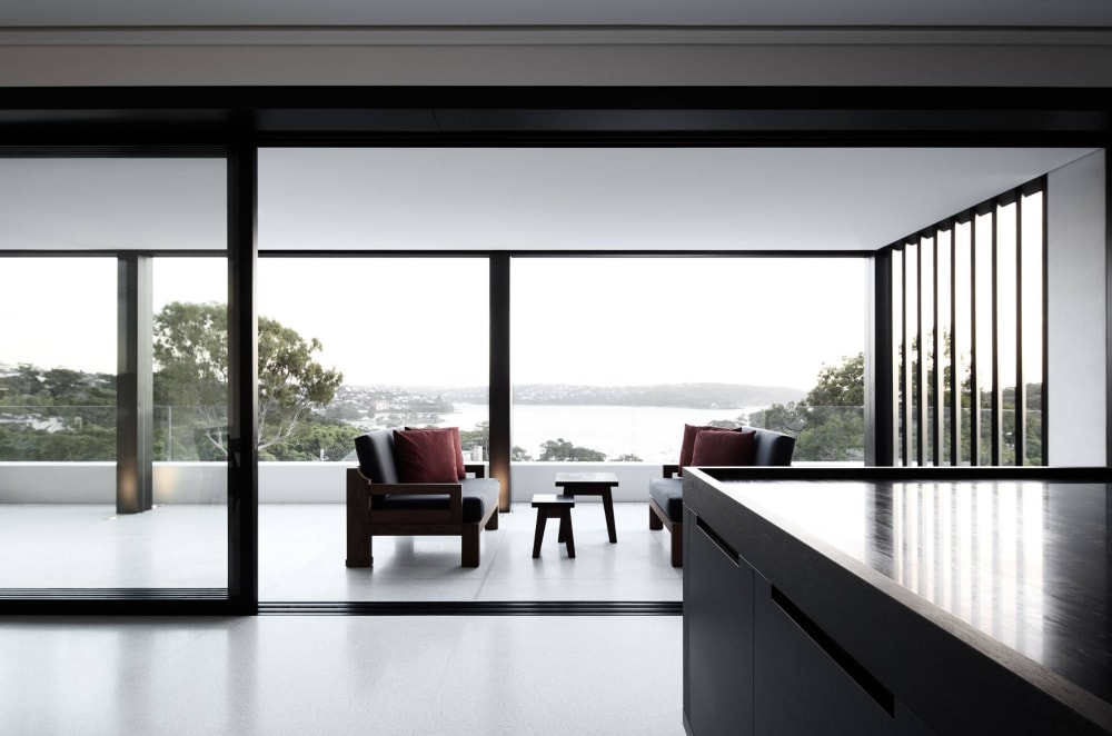 Interior opening on a balcony with a glazed balustrade that divides it from the deep vista over the sea.<span class="sr-only"> (opened in a new window/tab)</span>