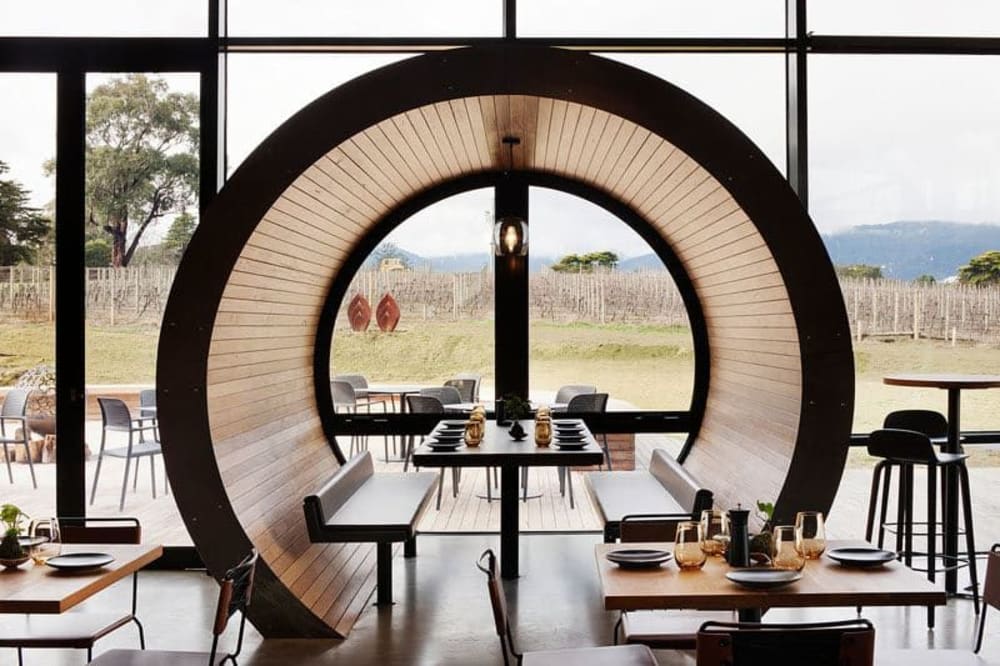 Restaurant table enclosed in a rounded wood structure.<span class="sr-only"> (opened in a new window/tab)</span>