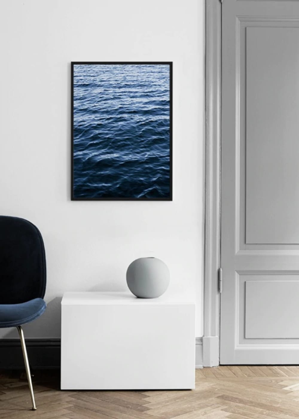 Artwork representing the texture of water on a white wall surrounded by minimal furnishings.<span class="sr-only"> (opened in a new window/tab)</span>