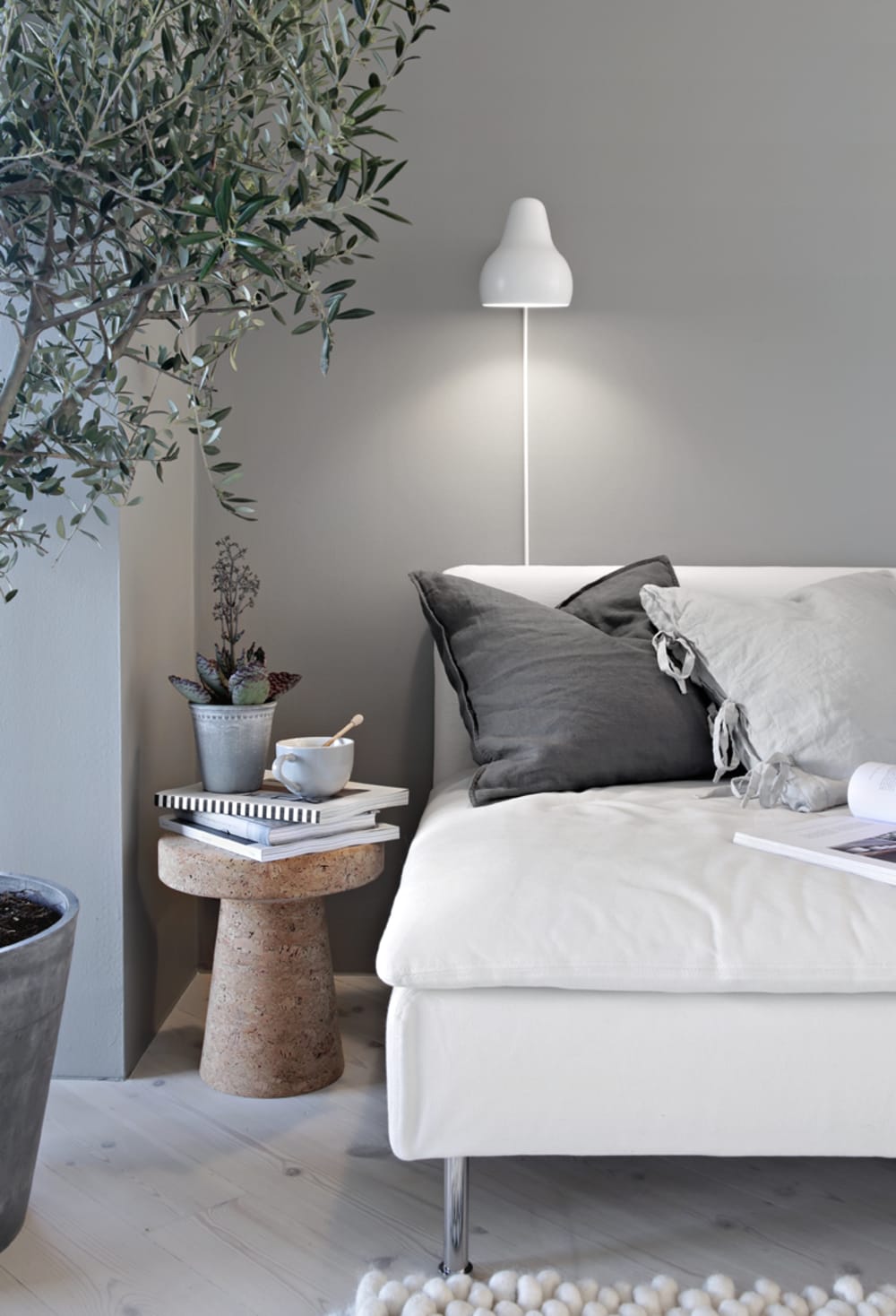 Sofa with soft cushions, a tea and few plants.<span class="sr-only"> (opened in a new window/tab)</span>