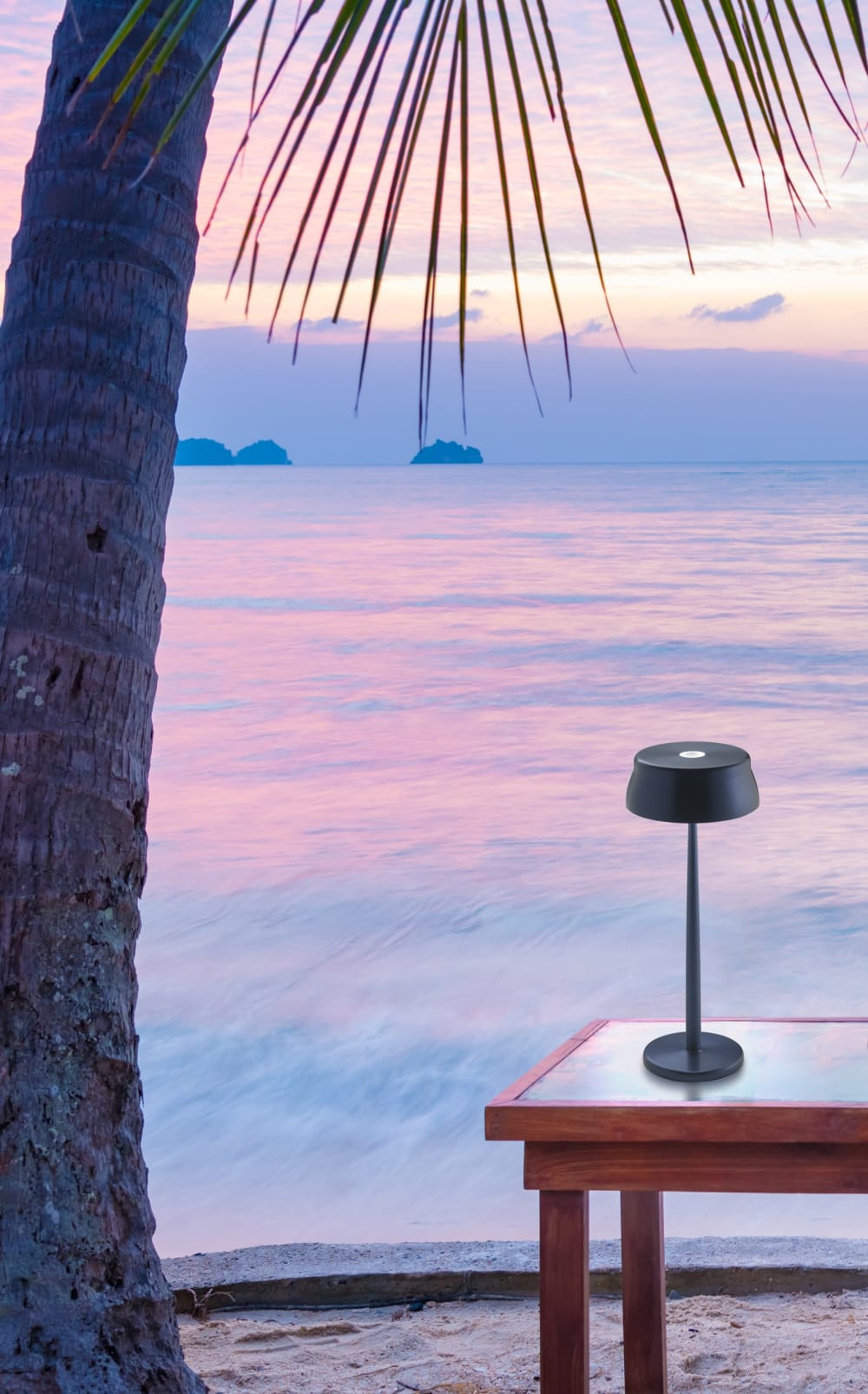 Portable table lamp on a table facing the sea at sunset.<span class="sr-only"> (opened in a new window/tab)</span>