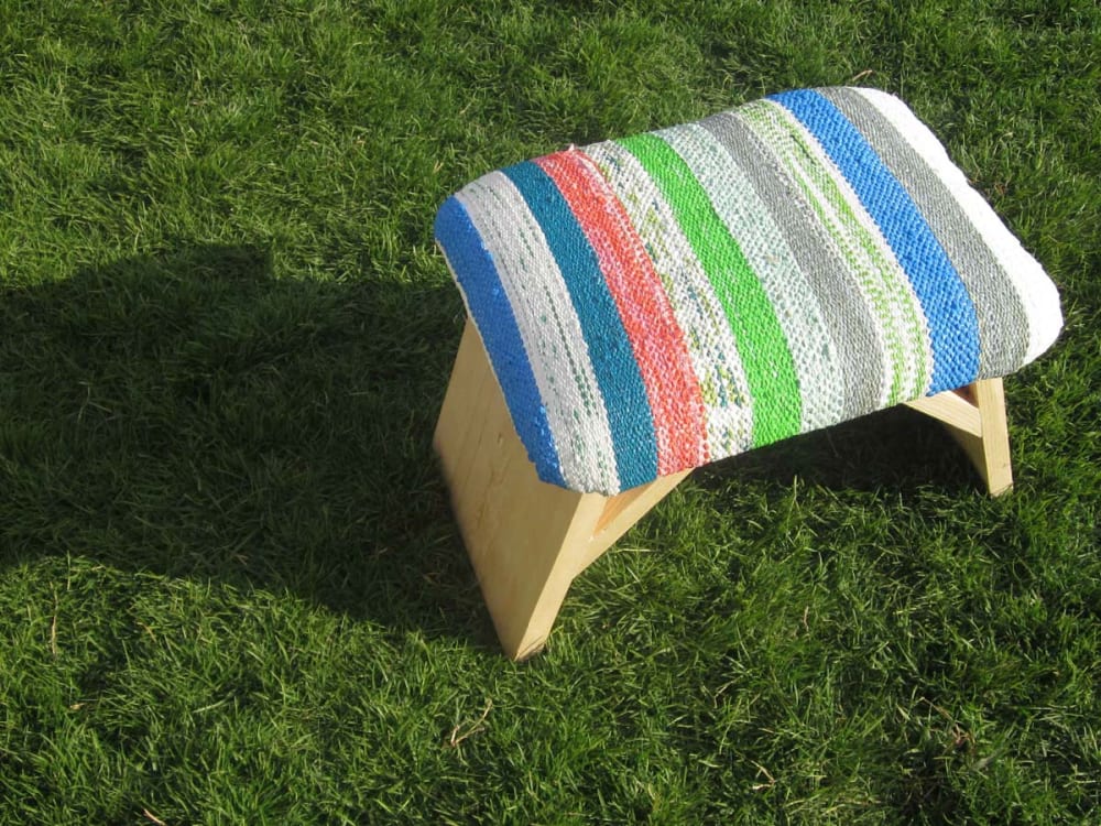 Wooden stool with seat upholstered with Plastex, a sustainable material made recycling plastic bags.<span class="sr-only"> (opened in a new window/tab)</span>