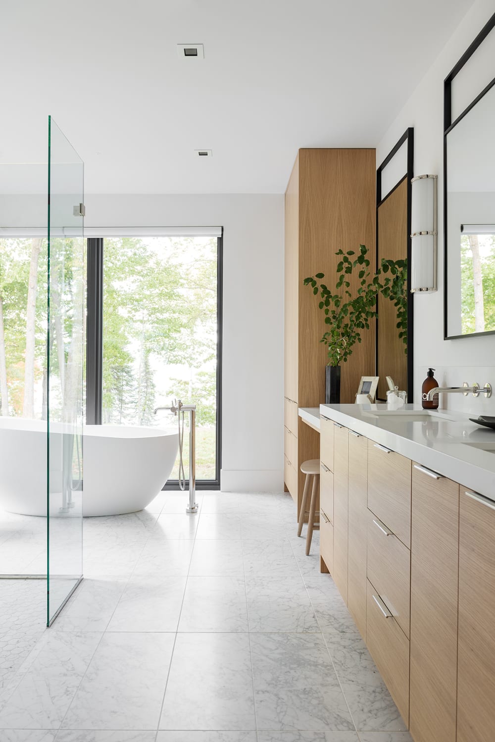 A relaxing bathroom full of sunlight, natural materials and full-height windows looking into nature.<span class="sr-only"> (opened in a new window/tab)</span>