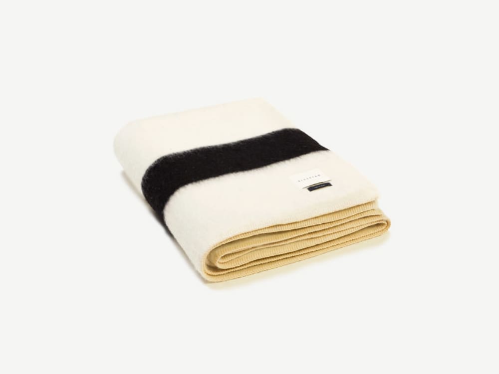 White blanket with a black stripe on the bottom.<span class="sr-only"> (opened in a new window/tab)</span>