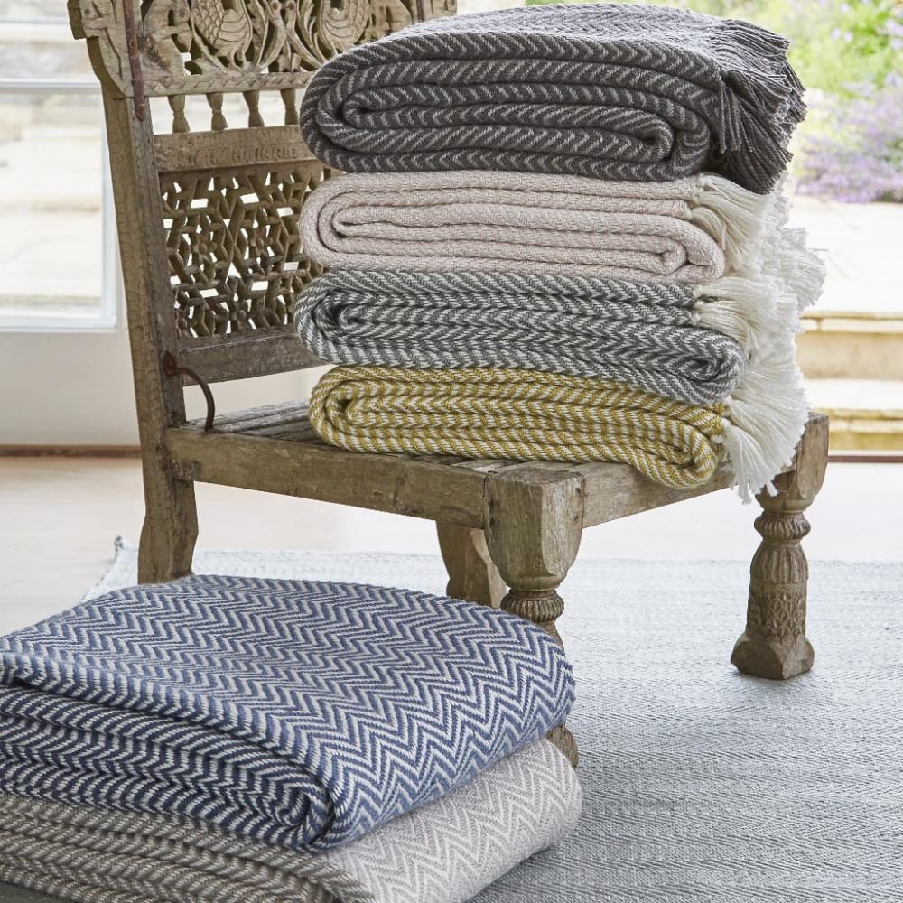 A pile of blanket stacked onto a Moroccan style low chair.<span class="sr-only"> (opened in a new window/tab)</span>