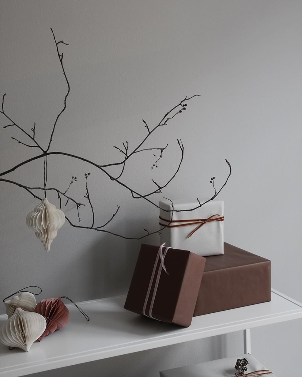 Branch decorated with paper ornaments in earthy tones.<span class="sr-only"> (opened in a new window/tab)</span>