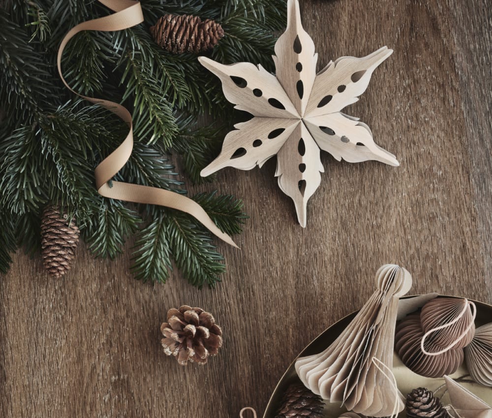 Paper sustainable Christmas ornaments on a wood background.<span class="sr-only"> (opened in a new window/tab)</span>