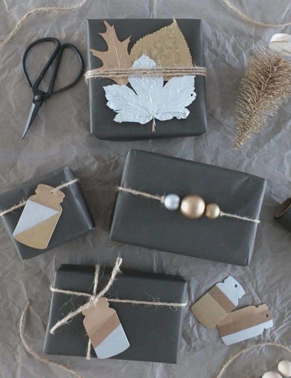 Black wrapping paper decorated with leaves, wood ornaments and cardboard cutouts.<span class="sr-only"> (opened in a new window/tab)</span>
